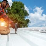 Roofer working at metal profile roof installation,Roofing tools,Electric drill used on new roofs.